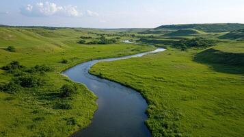 an aerial view of a river flowing through a green valley photo