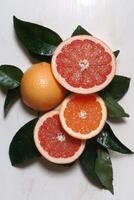 Close up of juicy pink grapefruits with green leaves photo