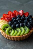 Delicious fruit tart with strawberries, blueberries, kiwi, and banana photo
