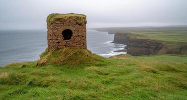 Stone ruin on a green cliff overlooking the ocean photo