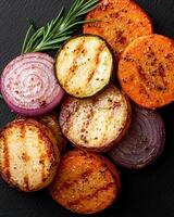 Delicious grilled vegetables on a black background photo