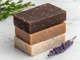 Three bars of handmade soap stacked on a marble surface with lavender photo