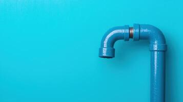 Blue water pipe with elbow joint and water droplets on a turquoise background. Close-up image. Plumbing and utility concept. photo