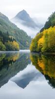 Misty Morning Lake Surrounded by Forest and Mountain Reflection in Autumn with Colorful Foliage and Serene Atmosphere photo