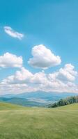 Serene Summer Day with Fluffy White Clouds and Vast Green Landscape Underneath Clear Blue Sky photo