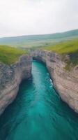 Drone View of Dramatic Cliffs and Turquoise Ocean Waters with Lush Greenery on Horizon in Serene Landscape photo
