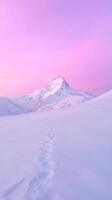 Snowy mountain peak under a vibrant pink sky with footprints leading through the pristine snow Winter landscape and adventure concept for exploration and nature design photo