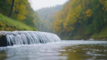 Small Waterfall Amidst Autumn Forest with Soft Focus, Serene Landscape Reflection, Calm Nature Scene on Cloudy Day, Gentle Stream Flow, Vibrant Foliage, Tranquil Atmosphere, Peaceful Wilderness photo
