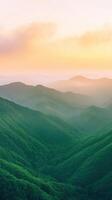 Sunrise Over Lush Green Mountain Range Scenic Nature View in Vertical Composition with Soft Pastel Sky and Mist Covered Valleys for Serene Landscape Photography and Tranquil Meditation Settings photo