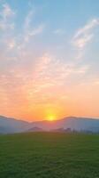 Beautiful Sunset Scene with Vibrant Colors and Cloudy Sky Over Green Field in Simi Valley Capturing Evening Tranquility and Natural Serenity as Sun Sets Behind Mountains photo