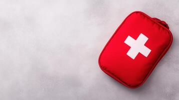 Red First Aid Kit on Gray Background Isolated for Medical Emergency Safety, Health Care Preparation, Survival Essentials with Copy Space for Text in Minimalistic Design and Modern Style photo