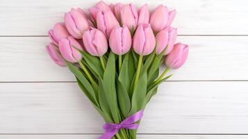 Bouquet of Pink Tulips Tied with a Purple Ribbon Resting on Light Wooden Surface for Spring Floral Composition and Decoration photo