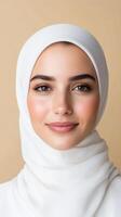 Portrait of Smiling Woman Wearing White Hijab on Beige Background with Radiant Expression and Soft Lighting for Cultural Representation and Inspirational Stock Photography photo