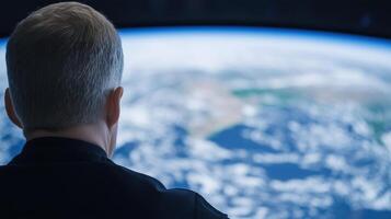 Person observing Earth from space through a large window with a blurred planetary view Space exploration and observation concept focusing on human connection with the planet photo