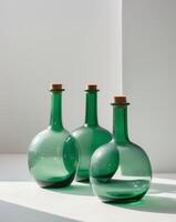 three green bottles with corks on a white surfacethree green bottles with corks on a white surface. photo