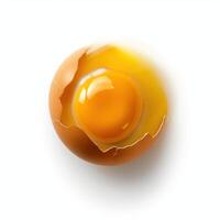 Freshly cracked egg shell revealing bright yellow yolk on a clean white background during food preparation photo