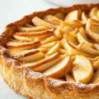 Delicious apple tart showcasing golden, thinly sliced apples on a flaky pastry crust with a glossy finish photo