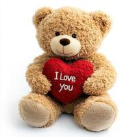 Soft teddy bear holding a heart-shaped pillow with a loving message on a white background photo