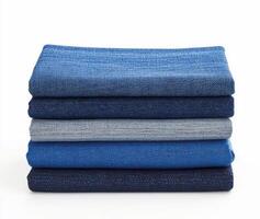 Five stacked rolls of denim fabric showcasing various shades of blue in a clean, minimalist display photo