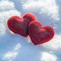 Red heart decorations resting on fresh snow during winter season creating a romantic atmosphere photo