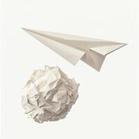 Crumpled paper ball and paper airplane suspended in mid-air above a plain backdrop photo