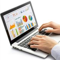 Hands typing on laptop while analyzing colorful graphs and charts in a modern workspace environment photo
