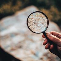 Exploring new destinations with a magnifying glass over a detailed map outdoors photo