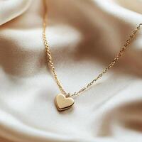 Beautiful gold heart pendant necklace resting on soft satin fabric, highlighting elegance and simplicity in jewelry design photo