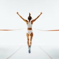 Female athlete crossing the finish line with arms raised in celebration during a track and field event photo