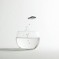 Fish jumps out of a clear bowl filled with water, creating splashes in a minimalist setting photo