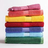 Stacked towels in vibrant colors displayed on a clean surface during daytime photo