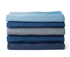 Stacked layers of various shades of blue linen fabric on a plain background photo