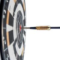 Dart striking the bullseye on a dartboard in a well-lit indoor setting photo
