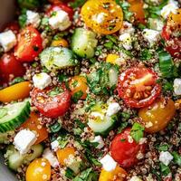 Colorful quinoa salad with cherry tomatoes, cucumbers, and feta cheese for a fresh meal photo