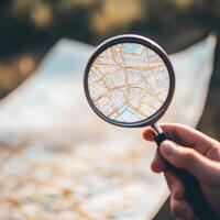 Exploring a detailed map with a magnifying glass outdoors in bright daylight photo