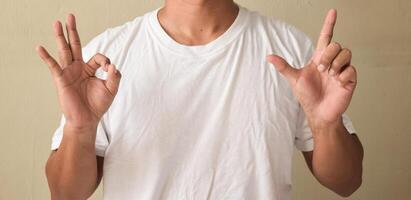 Young man view of pleased teacher showing alphabet letters on sign language photo