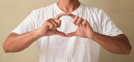 Young man learning sign language, making ellipse with his fingers photo