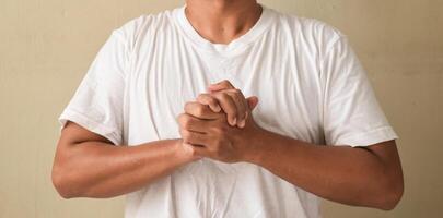 Young man showing symbol meaning friendship on sign language photo
