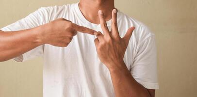 Young man raising hands while talking on sign language, showing word counting photo