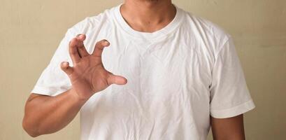 Young man keeping his hand raised while using sign language photo