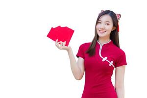 Young Asian beautiful girl in red dress stands and holds red envelope with an excited expression while isolated on white background in Chinese new year theme. photo