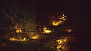 Mystical stairway with flickering candles illuminating the hidden cave video