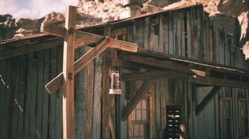 Rustic wooden building with lantern in a remote desert setting during daylight video