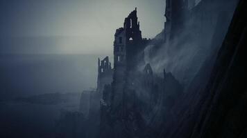 Dramatic view of a ruined castle on a cliff overlooking the ocean at dusk video
