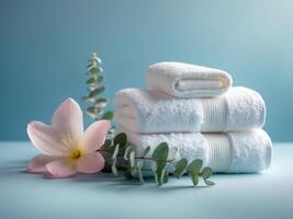 Spa Essentials with Soft Towels and Fragrant Flowers on a Serene Blue Background. photo