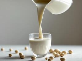 Soy milk pouring into glass featuring healthy soybeans in a vegan drink image photo