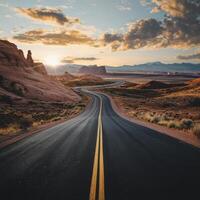 A long road with a yellow line down the middle photo