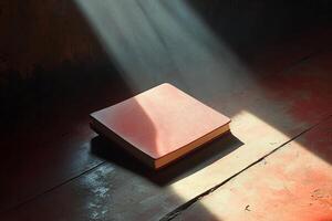 A book is sitting on a wooden table with sunlight shining on it photo