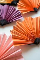 A collection of colorful paper fans are arranged in a row photo