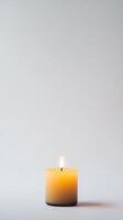 A candle is lit and sits on a white background photo